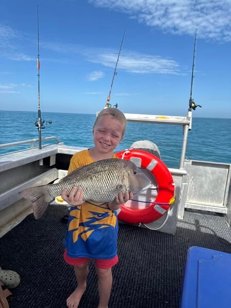 Young boy from the King family holding a black snapper caught on a fishing trip with Monkey Mia Boat Hire in Shark Bay.